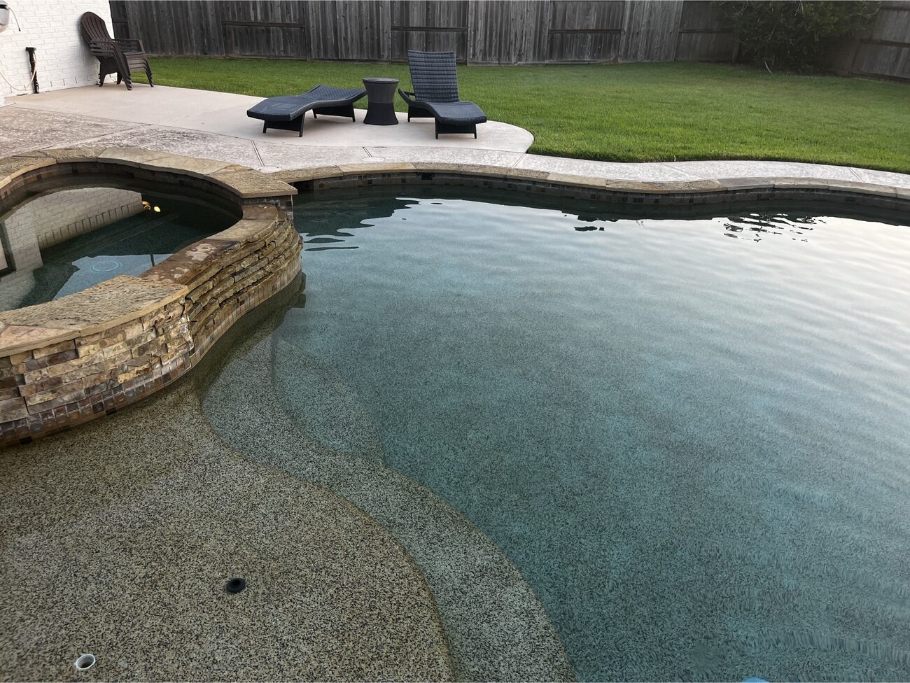 Crystal-clear Tampa pool with spa and loungers maintained by Neptune Reliable Pool Service